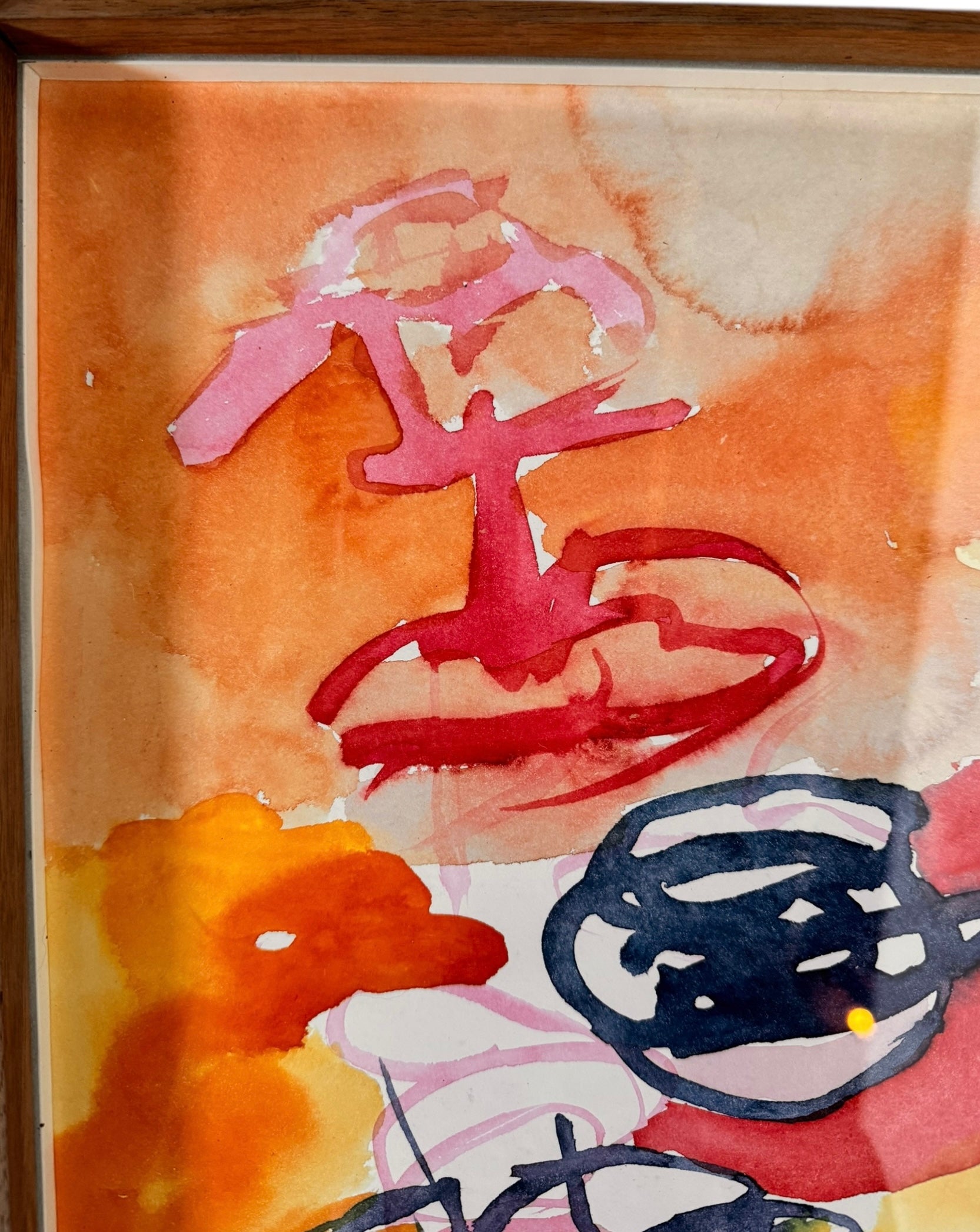 A vertical watercolor painting on paper, framed in a simple dark wood frame. The piece consists of a lively arrangement of gestural, loopy shapes and washes in a warm palette of apricot, magenta, and deep navy blue. The shapes are layered and translucent, with some areas featuring saturated "blooms" of color and others showing thin, wiry line work. The artist's signature and the year '97 are visible in the bottom right corner.