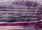 A horizontal, rectangular abstract print titled "Night Water" centered within a white mat and a thin gold frame. The artwork features dense, textured horizontal brushstrokes in deep shades of violet, indigo, and black. A prominent, gestural streak of vibrant red and a softer blush-pink band cut across the dark "water," suggesting a sunset reflection or light hitting a dark surface. The artist's signature, title, and the year 2004 are visible in pencil at the bottom.