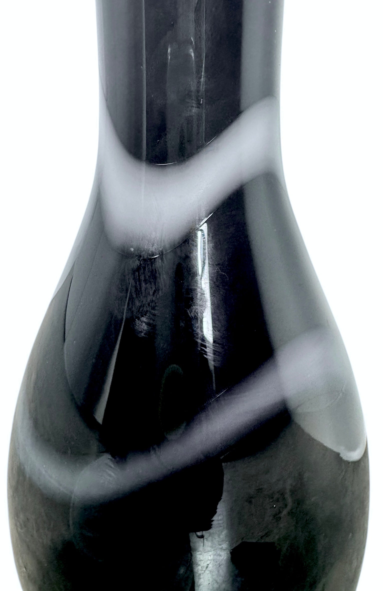 A sleek, hand-blown Polish art glass vase featuring a tall, slender neck that flares into a rounded, bulbous body. The vase is made of opaque black glass decorated with a continuous white spiral ribbon that winds around the entire piece from base to rim. The high-gloss, reflective surface creates sharp highlights, emphasizing its smooth, sculptural silhouette against a plain white background.
