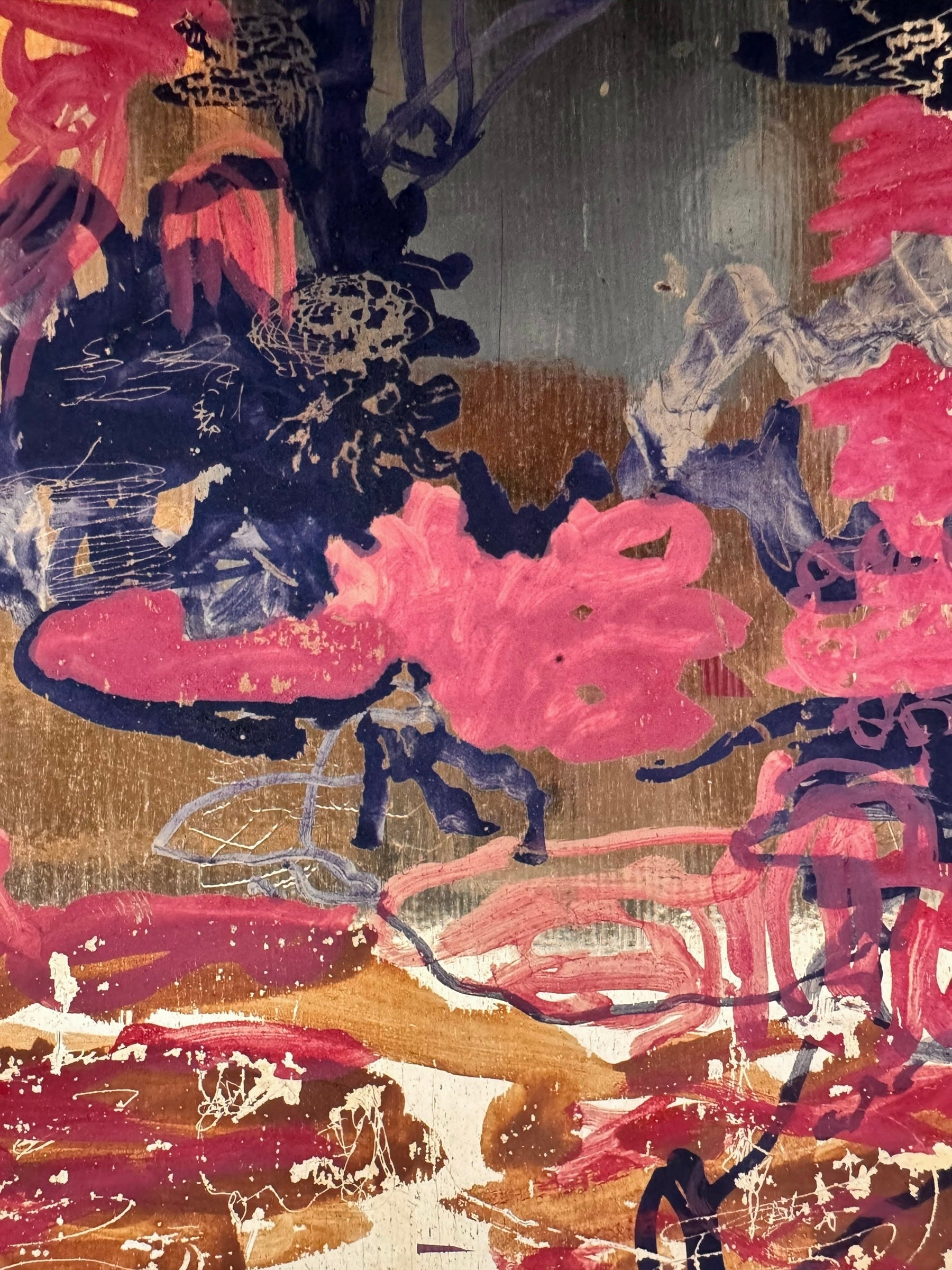 A vibrant abstract painting on a metallic gold-toned panel characterized by dense, energetic layering. The palette is dominated by saturated pinks, deep blacks, and earthy oranges.
In the upper half, horizontal strokes of orange and pink suggest a sunset or landscape, while the lower half features heavy, gestural applications of black paint that anchor the composition. Fine, white or silver linear scribbles are scratched into or layered over the pigment, adding a sense of frantic movement.