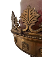 A tall, ornate, antique brass or bronze Gothic church candlestick holder with a pink candle in the top.