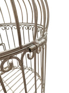 A single, white or cream-colored, decorative wrought iron bird cage with a hinged door and a hanging loop at the top. The cage has a vintage or antique style 