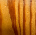 A wooden sculpture featuring a dark square base, a vertical trunk that branches into two angled supports, and a turned wooden sphere resting on the higher support.