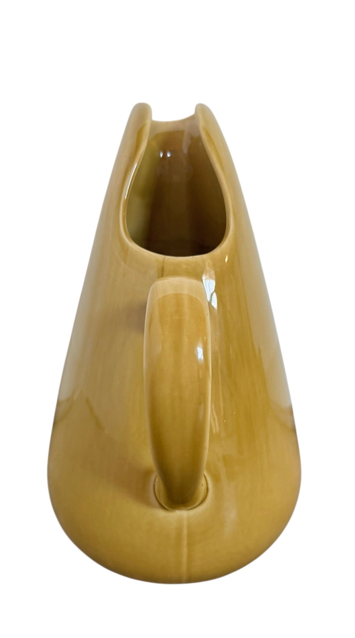 A chartreuse (yellow-green) ceramic pitcher designed by Russel Wright, featuring a teardrop shape, an elongated spout, and a curved handle