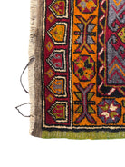 Anatolian Yastik rug with red, gold, green and gray geometric patterns and fringe.
