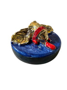 Ceramic foot sculpture by Domenico Pinto featuring hand-painted details, gold accents, a sacred heart, and an angel figure with a blindfold