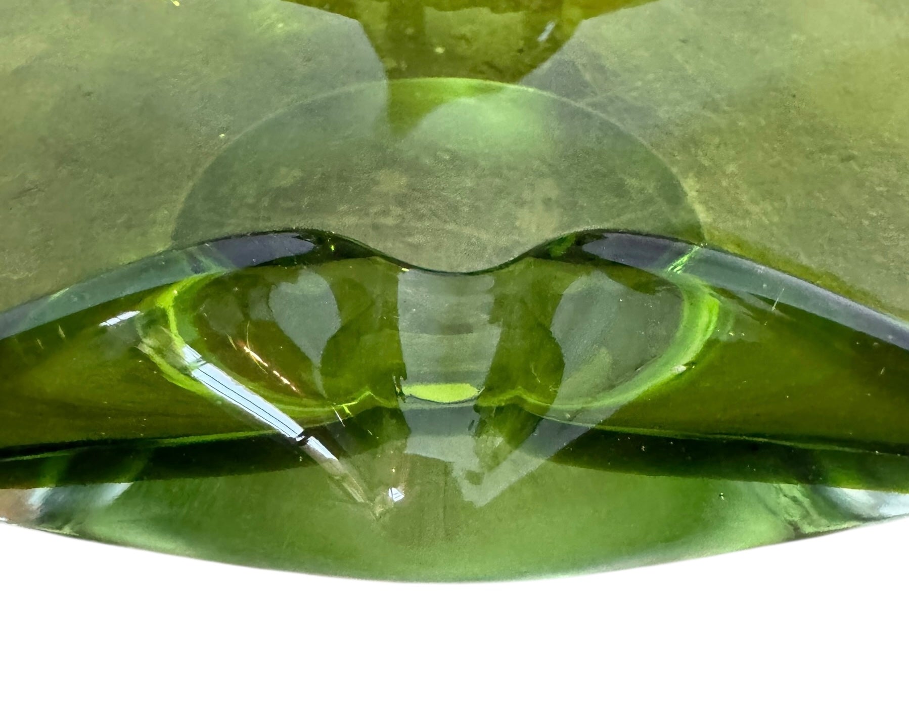 A vintage, Mid-Century Modern, peridot green art glass ashtray or catchall bowl with a curved, free-form design.