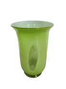 A mid-century modern, lime green cased-glass vase with a wide, flared rim and a thick, clear glass base. The exterior is a glossy chartreuse green, while the interior is lined with solid milk-white glass. The defining feature is a large, vertical oval cutout window that pierces directly through the center of the vase's body, creating an open-air negative space.