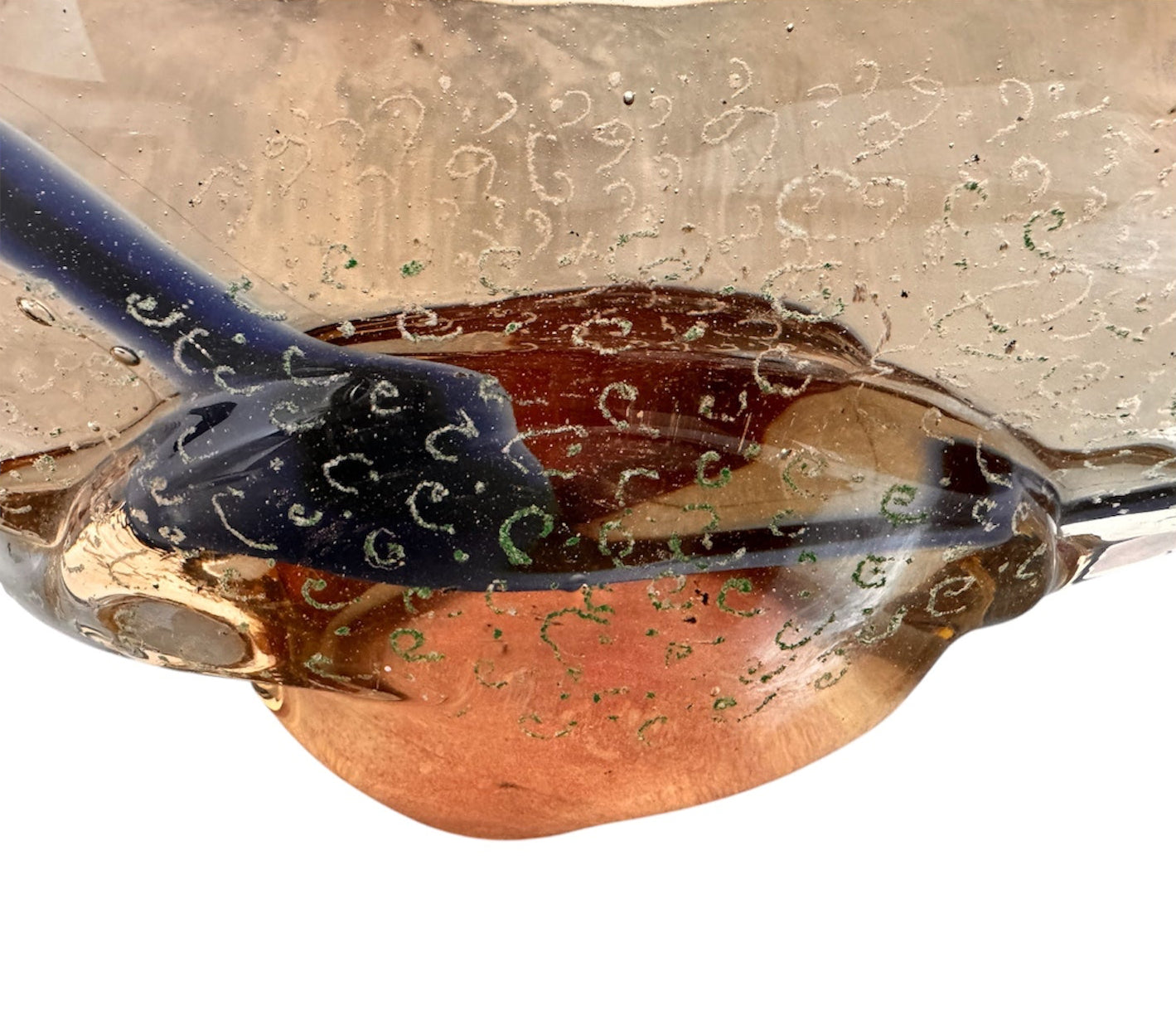 An asymmetrical Murano art glass sculpture with a heavy, biomorphic form. The piece is composed of thick, translucent smoky-amber glass with abstract, fluid bands of deep blue and dark brown swirling throughout the upper rim and sides. A dense pattern of tiny, controlled air bubbles is suspended inside the glass, concentrating heavily near the thick, solid amber base.