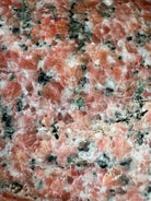 A carved pink granite planter with a leaf pattern, designed for indoor use without drainage.
