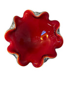 A Murano art glass bowl featuring a vibrant red interior encased in white glass, with a decorative ruffled edge. The piece is handblown, showcasing the Incamiciato technique.