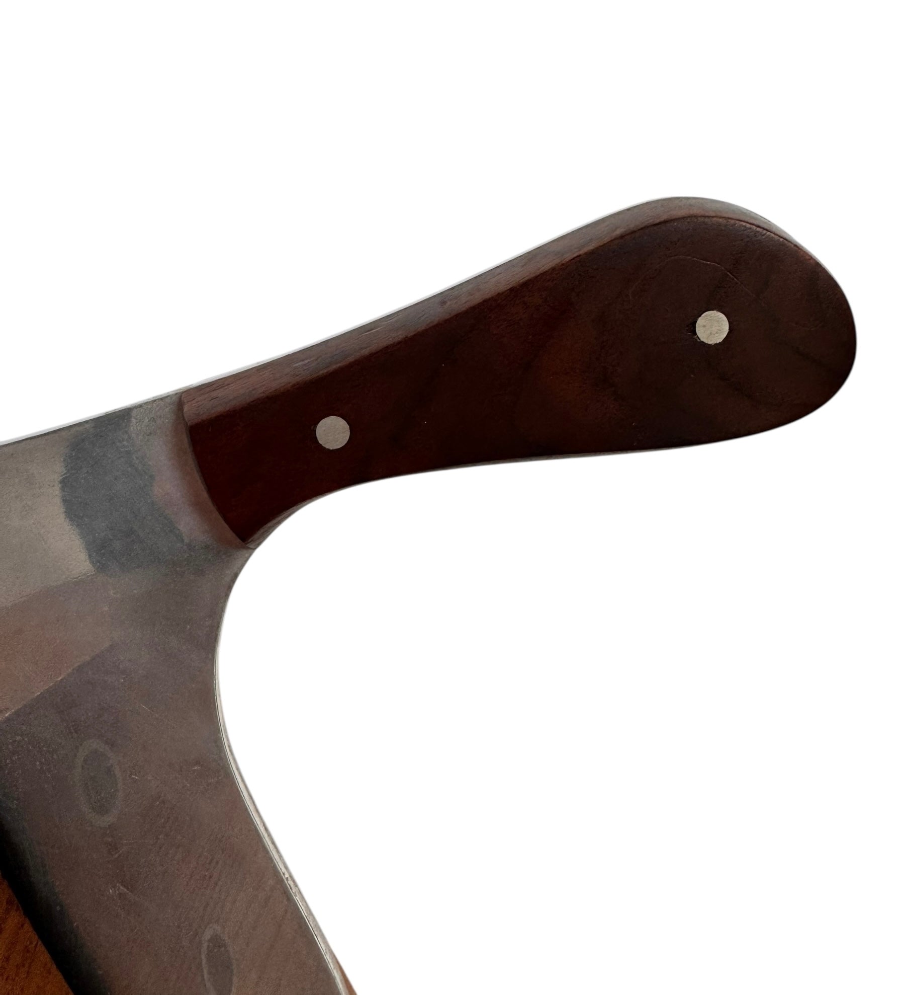 A wooden sculpture with a highly polished, reddish-brown grain, featuring two main asymmetrical, curved sections that converge at the top. Circular metal inlays with black centers are embedded across the surface of both wooden sections. A flat, polished metal blade-like element is inserted vertically between the two wooden sections, extending above the top surface. The sculpture rests on a metallic base.