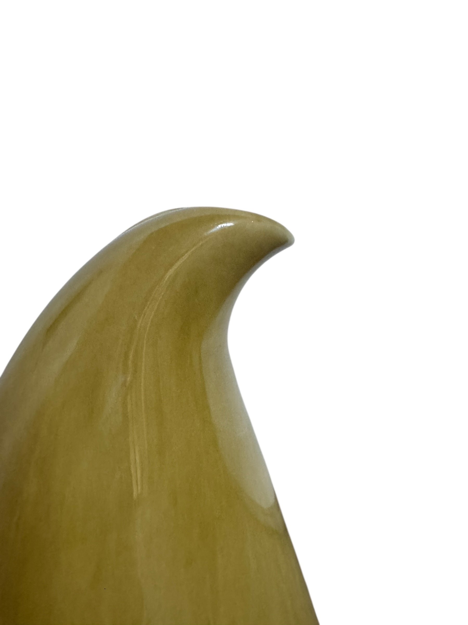 A chartreuse (yellow-green) ceramic pitcher designed by Russel Wright, featuring a teardrop shape, an elongated spout, and a curved handle