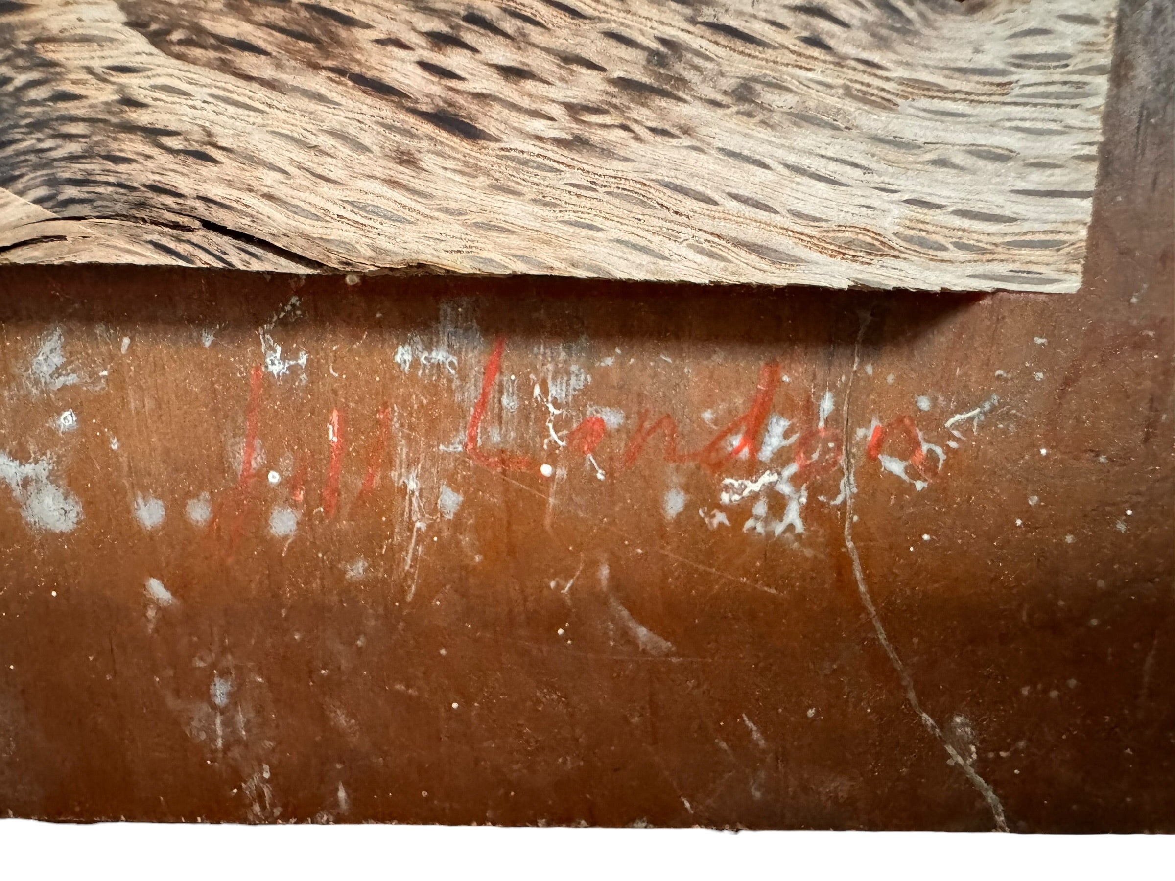 A vertical composition on a bright, reflective metallic background (likely silver or light gold leaf). The piece is defined by sparse, high-energy gestures: a sweeping arc of orange and red at the top, a central cluster of textured red paint, and a scattering of teal-blue "C" shapes and hooks. The metallic surface is highly visible, giving the piece a luminous, modern feel.