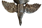 A pair of vintage, silver-plated brass fighting rooster figurines positioned in a confrontational stance against a white background. The rooster on the left is crouched low with its head down and tail feathers fanned high, while the rooster on the right stands more upright with its wings slightly flared. Both feature intricate feather detailing, a metallic patina showing hints of brass through the silver, and small, bright red glass eyes.