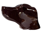 A glossy, dark chocolate brown ceramic bust of a Labrador dog. Created by Enza Fasano, the sculpture features a minimalist, stylized design with smooth, flowing lines and a high-shine glaze that reflects light. The dog’s long ears drape down the sides, and its snout is rounded, capturing the gentle essence of the breed in a contemporary Italian pottery style.