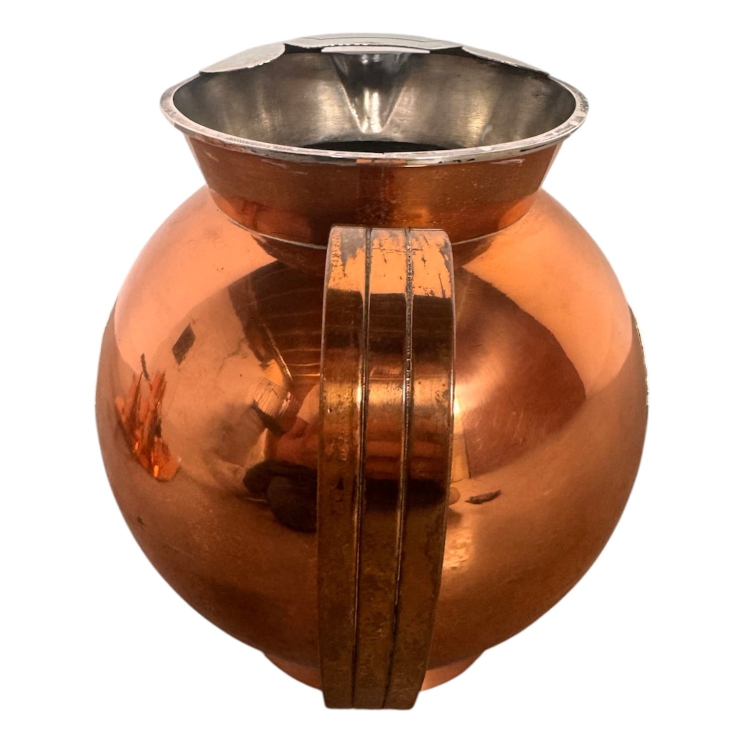 The set includes a large, rectangular, hammered copper tray with geometric openwork handles. Resting on the tray is a tall, slightly tapered copper coffee pot with a wooden handle, a matching smaller creamer pitcher with a similar wooden handle, a lidded sugar bowl, and a tiny matching metal cup or jigger. To the right off the tray sits a large, spherical copper water pitcher or jug with a wide mouth and ice lip.