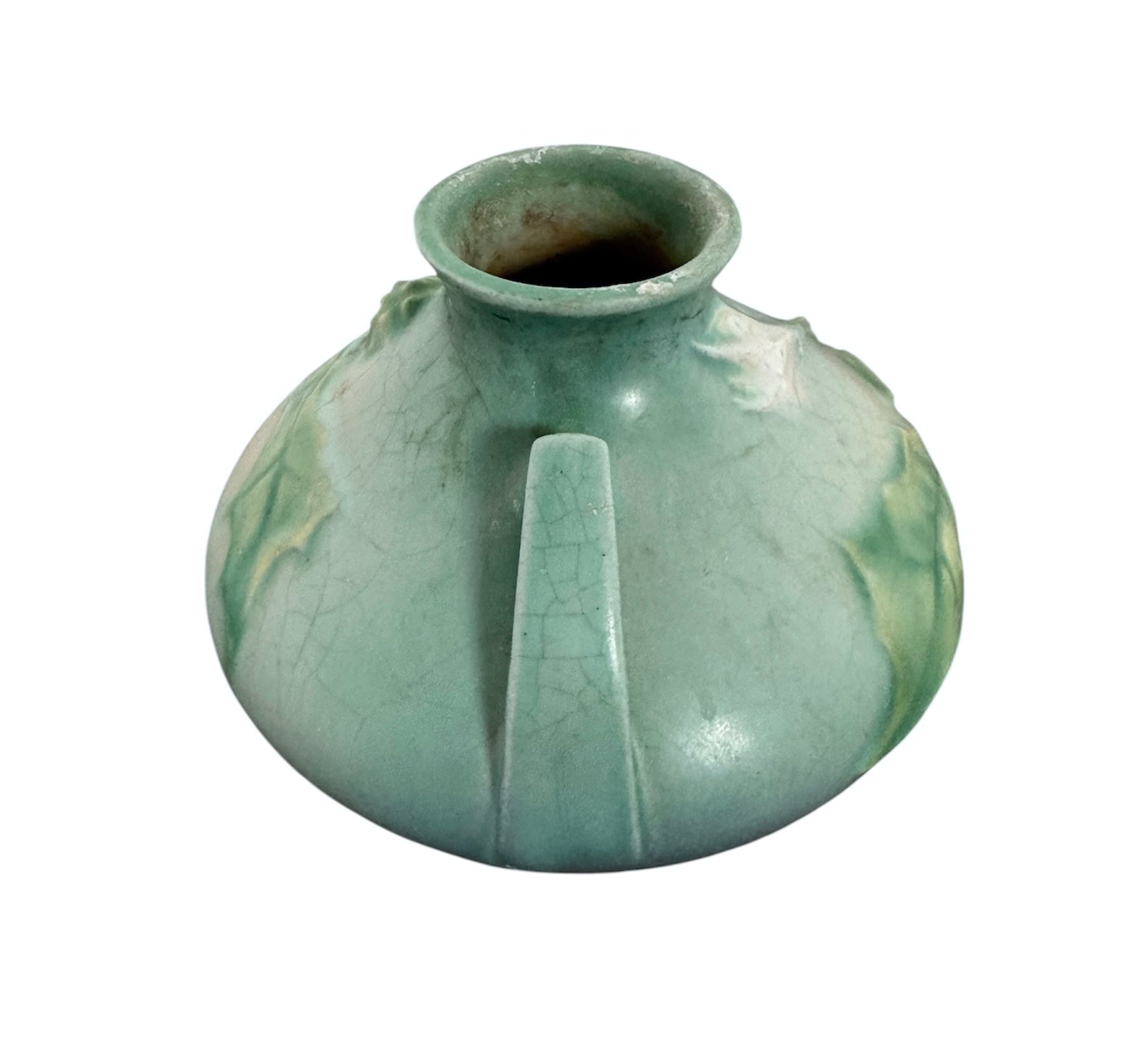 A squat, rounded vintage Roseville pottery vase in a light teal-blue matte glaze. The vase features two small, angular geometric handles on its shoulders and a flared rim. Embossed on the front is a cluster of textured, green and pale-yellow thornapple blossoms tucked against sharp, serrated green leaves. The surface shows a subtle, fine network of age-related crazing lines throughout the glaze.