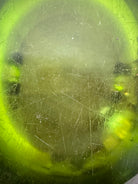 A vintage, Mid-Century Modern, peridot green art glass ashtray or catchall bowl with a curved, free-form design.