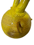 Yellow ceramic sculpture titled 'The Ram Oracle' by Enza Fasano, featuring a round body with intricate, hand-incised patterns and long, stylized ram-like horns