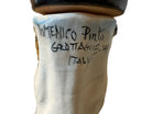 Ceramic foot sculpture by Domenico Pinto featuring hand-painted details, gold accents, a sacred heart, and an angel figure with a blindfold