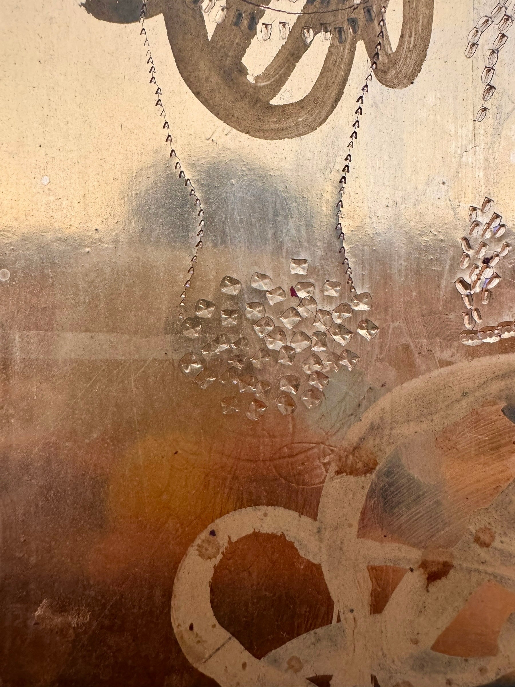 A vertical abstract work on a weathered gold-leaf panel. The upper section features bold, dark red calligraphic symbols resembling distorted kanji or script. Below, delicate, dotted white lines wind through the composition like strings of pearls or constellations. A slender, vertical form in vibrant red stands on the right, while muted, smoky-grey washes of paint ground the bottom of the piece.