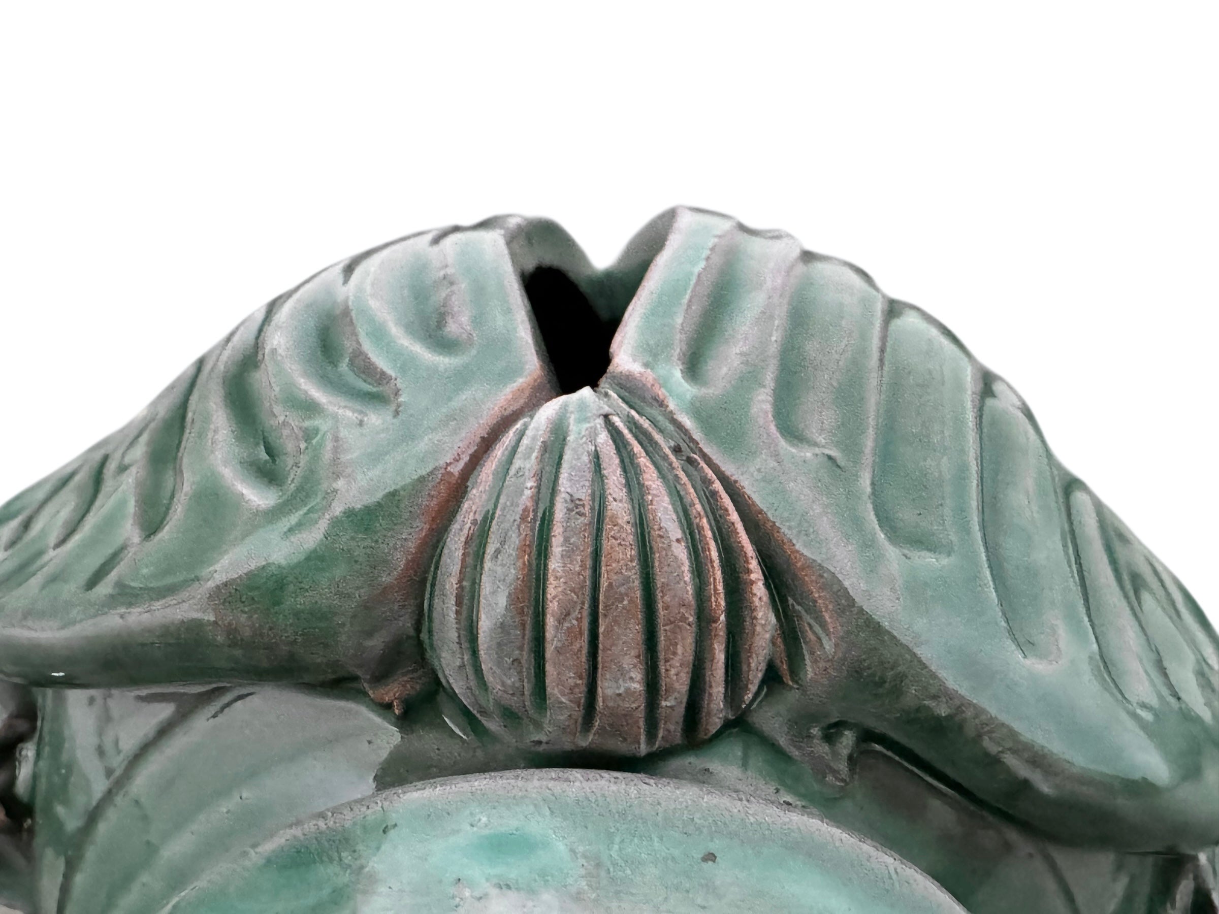 A ceramic sculpture of a stylized beetle by Enza Fasano, featuring a deep emerald green glaze with dark, metallic bronze-colored accents. The beetle is depicted with a highly textured, ribbed shell (elytra) and prominent, curved horns. Its legs are stylized with suckers, reminiscent of octopus tentacles. The piece has a glossy finish and rests against a plain white background.