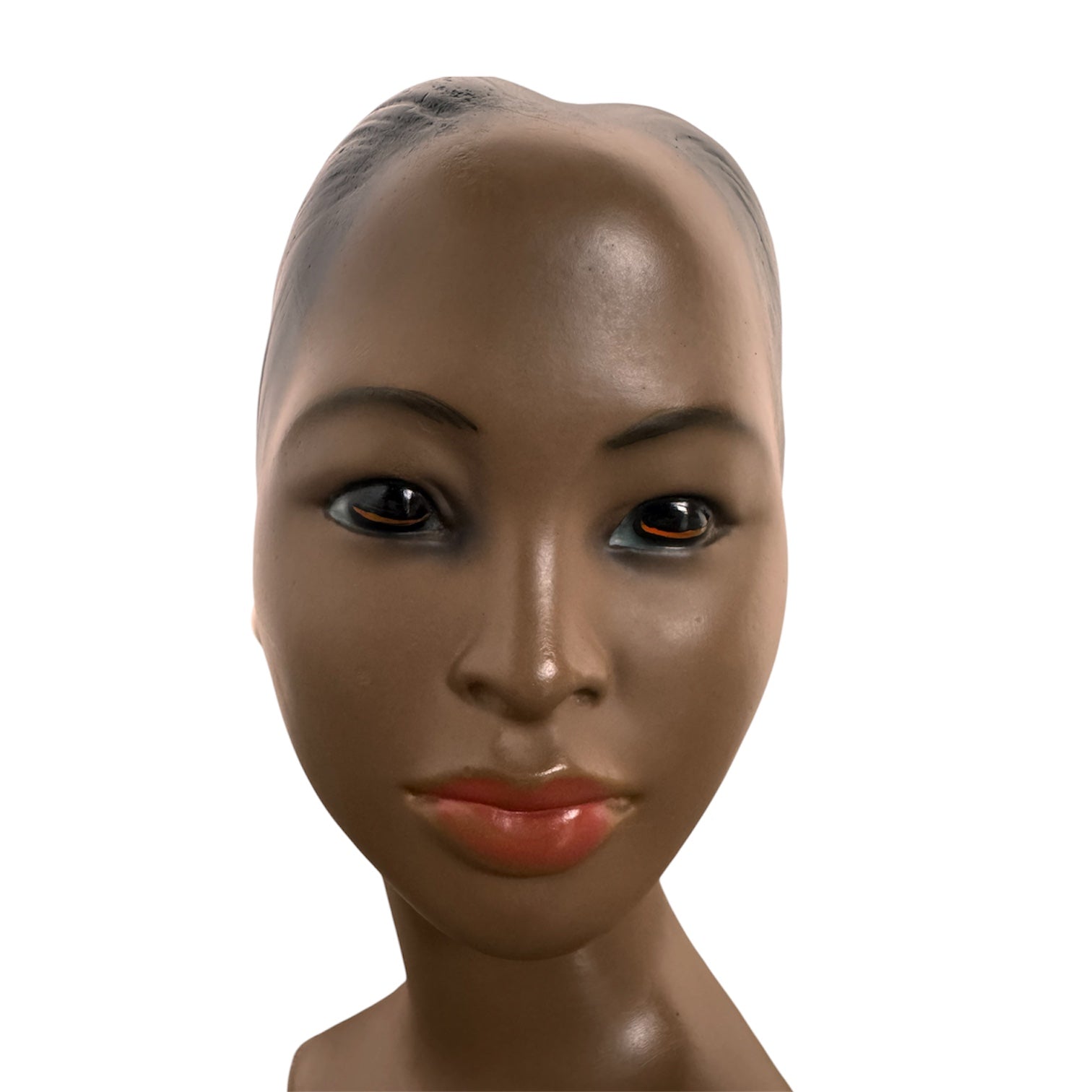 a vintage ceramic bust featuring a woman with brown skin, dark eyes, and orange lips. Her black hair is sleek and parted on the side, pulled back into a low style. She wears a small, round white earring in her right ear lobe. The bust includes her head, neck, and the upper part of her shoulders
