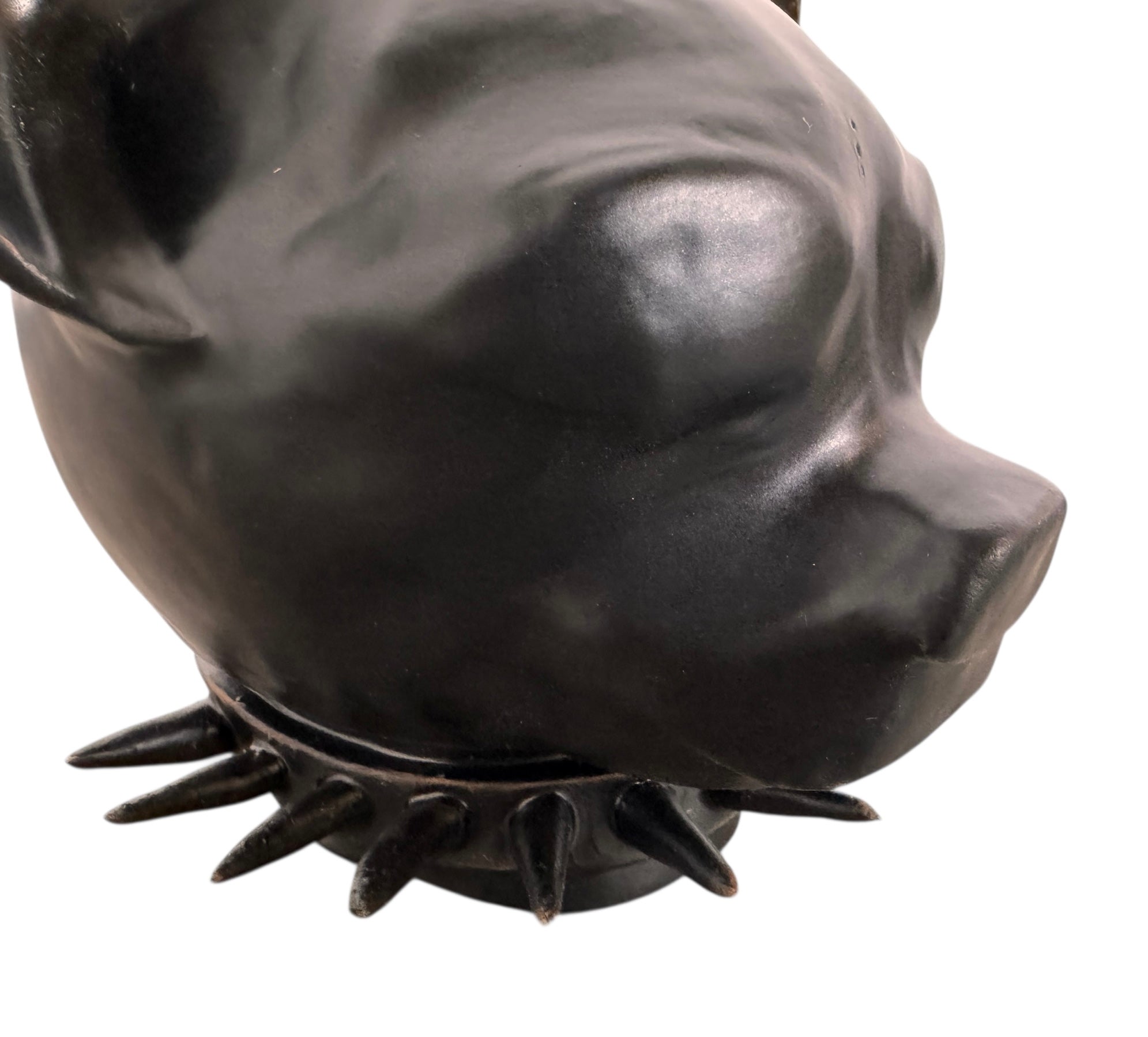 A smooth, dark black-colored ceramic sculpture of a Miniature Pinscher's head. The stylized dog features large, upright pointed ears and a prominent spiked collar around its neck. The surface has a soft sheen, with minimalist indentations for eyes and a rounded snout, creating a sleek and modern aesthetic.