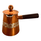 The set includes a large, rectangular, hammered copper tray with geometric openwork handles. Resting on the tray is a tall, slightly tapered copper coffee pot with a wooden handle, a matching smaller creamer pitcher with a similar wooden handle, a lidded sugar bowl, and a tiny matching metal cup or jigger. To the right off the tray sits a large, spherical copper water pitcher or jug with a wide mouth and ice lip.