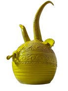 Yellow ceramic sculpture titled 'The Ram Oracle' by Enza Fasano, featuring a round body with intricate, hand-incised patterns and long, stylized ram-like horns