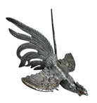 A pair of vintage, silver-plated brass fighting rooster figurines positioned in a confrontational stance against a white background. The rooster on the left is crouched low with its head down and tail feathers fanned high, while the rooster on the right stands more upright with its wings slightly flared. Both feature intricate feather detailing, a metallic patina showing hints of brass through the silver, and small, bright red glass eyes.