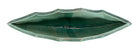 curved ceramic piece resembling a green pod, supported by a block plinth. The seafoam-green ceramic structure extends wide on either side, curving upward to form a wavy, boat-like shape. The outer surface is dotted with rows of small, raised, brown-orange, acorn-like protrusions. The top rim is layered with parallel, grooved ridges. The base is a vertical rectangular block with a heavily textured, bark-like surface in a dark green and black finish.