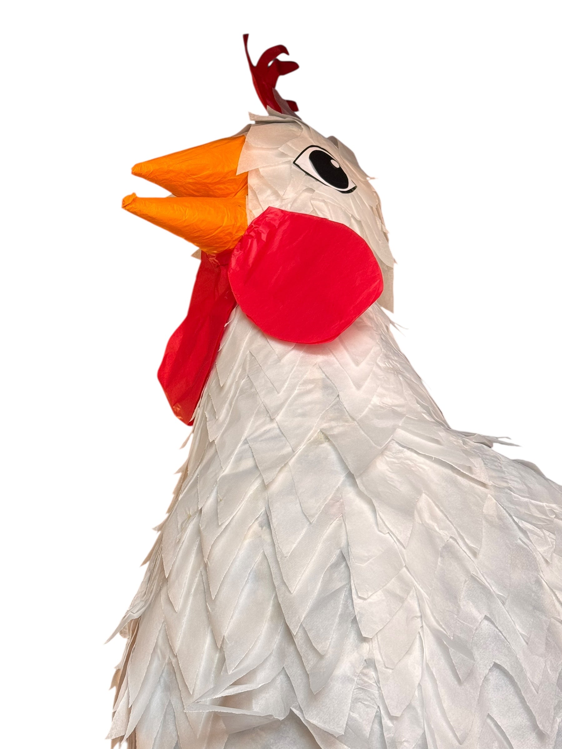 A white chicken pinata with red comb and wattles, and orange beak and legs, standing upright.