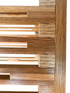 A three-tiered wooden shelving unit featuring a mix of light oak and teal-colored panels. The piece has an open, structural design with visible joinery, vertical supports that extend past the top shelf, and a horizontal backrest at the top. The middle and bottom shelves feature slatted wood center sections flanked by solid teal panels, while the top surface is primarily solid wood with teal accents at the edges.