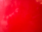 A top-down, straight-on view of a vintage, high-gloss cherry red bathtub. The tub basin is molded into a distinct double-tiered heart shape, with a shallower outer heart cascading into a deeper, smaller inner heart basin centered within a wide rectangular red deck.