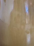 A chartreuse (yellow-green) ceramic pitcher designed by Russel Wright, featuring a teardrop shape, an elongated spout, and a curved handle