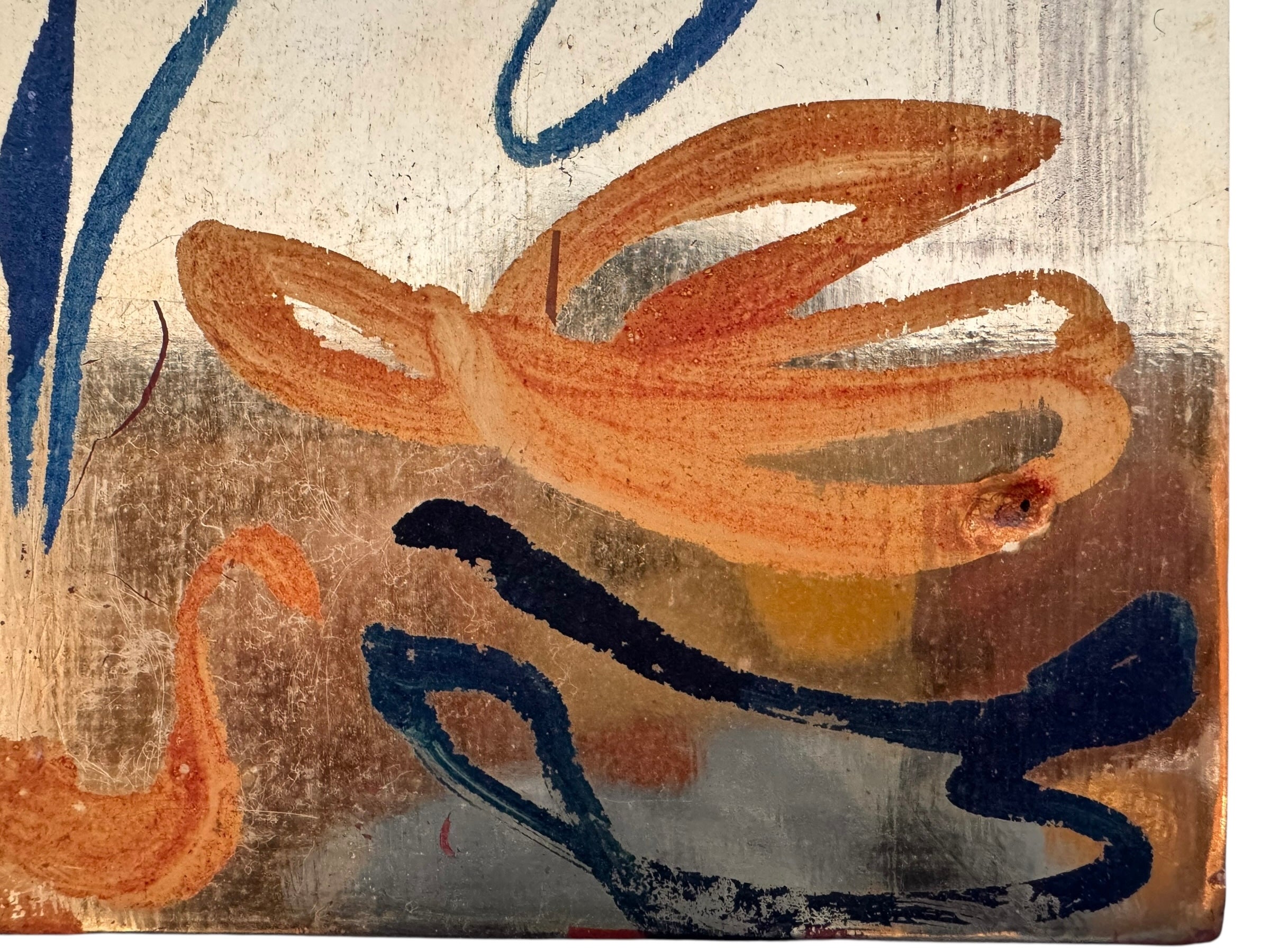 An abstract mixed-media painting on a vertical rectangular panel with a reflective, metallic gold and copper background. The composition features fluid, expressive brushstrokes in warm orange, ochre, and deep blue.
The orange strokes are thick and organic, resembling swirling flames or floral petals, while the blue marks consist of thin, lyrical lines and looped scribbles that dance across the surface. The metallic substrate is visible through the translucent paint, creating a play of light and texture