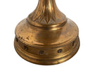 A tall, ornate, antique brass or bronze Gothic church candlestick holder with a pink candle in the top.