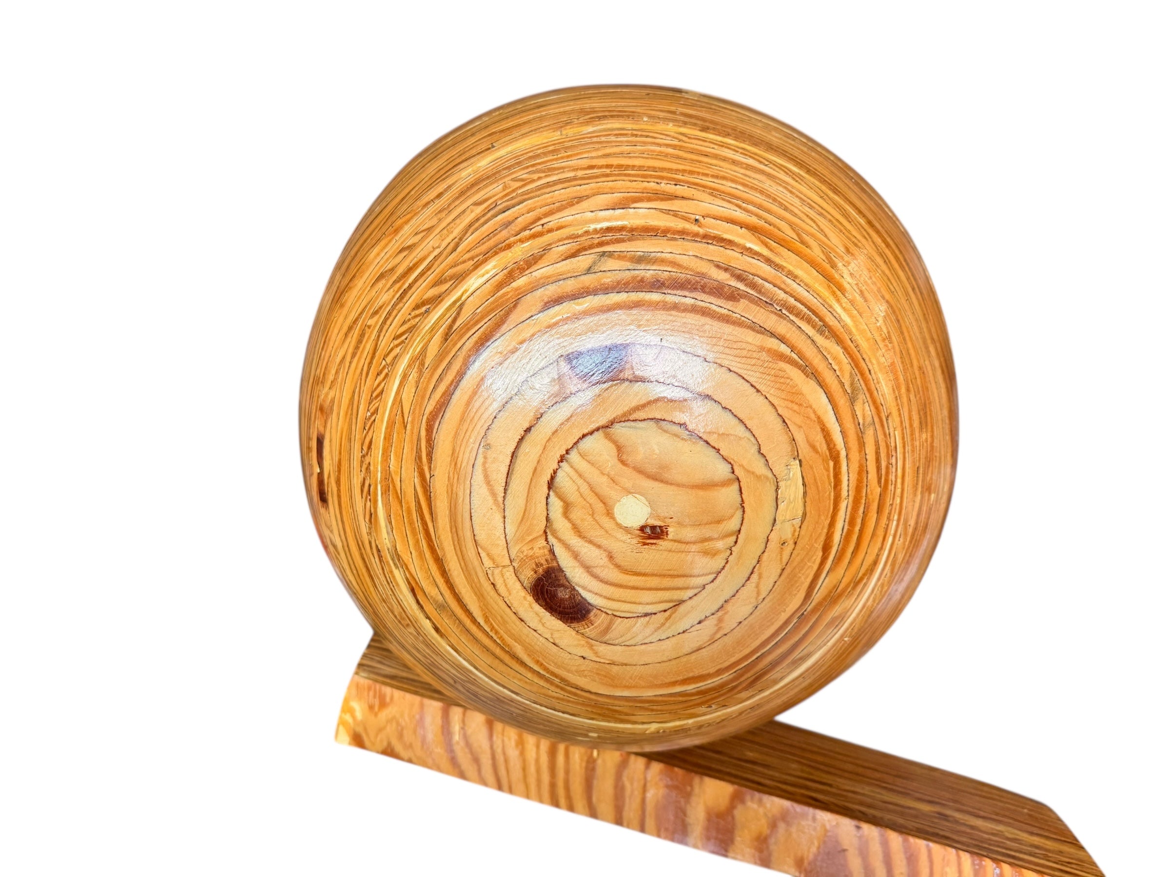 A wooden sculpture featuring a dark square base, a vertical trunk that branches into two angled supports, and a turned wooden sphere resting on the higher support.