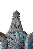 A pair of antique, heavily carved Anglo-Indian style throne chairs featuring lion figures as legs and arm supports, and peacock motifs on the backrests. The chairs have a distressed, multi-colored painted finish.