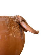 Terracotta colored ceramic Highland cow sculpture with a shaggy coat and curved horns