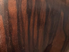 An elegant hand-carved bust of a woman made from rich, polished dark ebony wood with striking reddish-brown grain patterns running vertically through her face and chest. The sculpture features a serene expression with closed eyes, a slender nose, and relaxed lips. Her voluminous, textured hair rises upward in a Fan-like shape, intricately carved with fine lines and adorned with small, delicate flower details. The bust includes her bare shoulders and upper chest, resting on a flat base.
