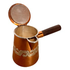 The set includes a large, rectangular, hammered copper tray with geometric openwork handles. Resting on the tray is a tall, slightly tapered copper coffee pot with a wooden handle, a matching smaller creamer pitcher with a similar wooden handle, a lidded sugar bowl, and a tiny matching metal cup or jigger. To the right off the tray sits a large, spherical copper water pitcher or jug with a wide mouth and ice lip.
