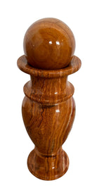 An elegant, hand-carved decorative vase made of polished Pakistani brown onyx. The vase features a classic, rounded urn shape with a tiered, flared neck and a solid matching spherical stone stopper resting on top. The stone displays rich, natural horizontal banding and swirling patterns in shades of honey, deep amber, rust-red, and cream. It stands on a small, integrated pedestal base against a clean white background, reflecting a high-gloss, mirror-like finish.