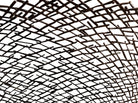 A round metal wall sculpture by Michael Aram, viewed from the front against a stark white background. The piece is composed of a dense, intricate lattice of fine, dark metal wire or twigs woven together to create a textured, web-like pattern. The structure curves inward like a funnel or a vortex, sloping down toward a clean, circular opening in the exact center, creating a strong sense of depth and dimensionality.