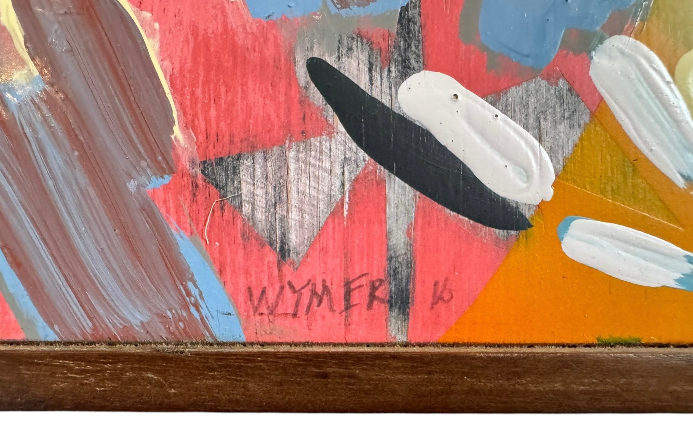 An abstract painting titled 'Cascade of Gold and Pink' by Robert Wymer, framed in dark wood. The artwork features a vibrant pink background densely covered with a dynamic arrangement of multi-directional, oblong, and dash-like brushstrokes in gold, red, blue, gray, white, and black.