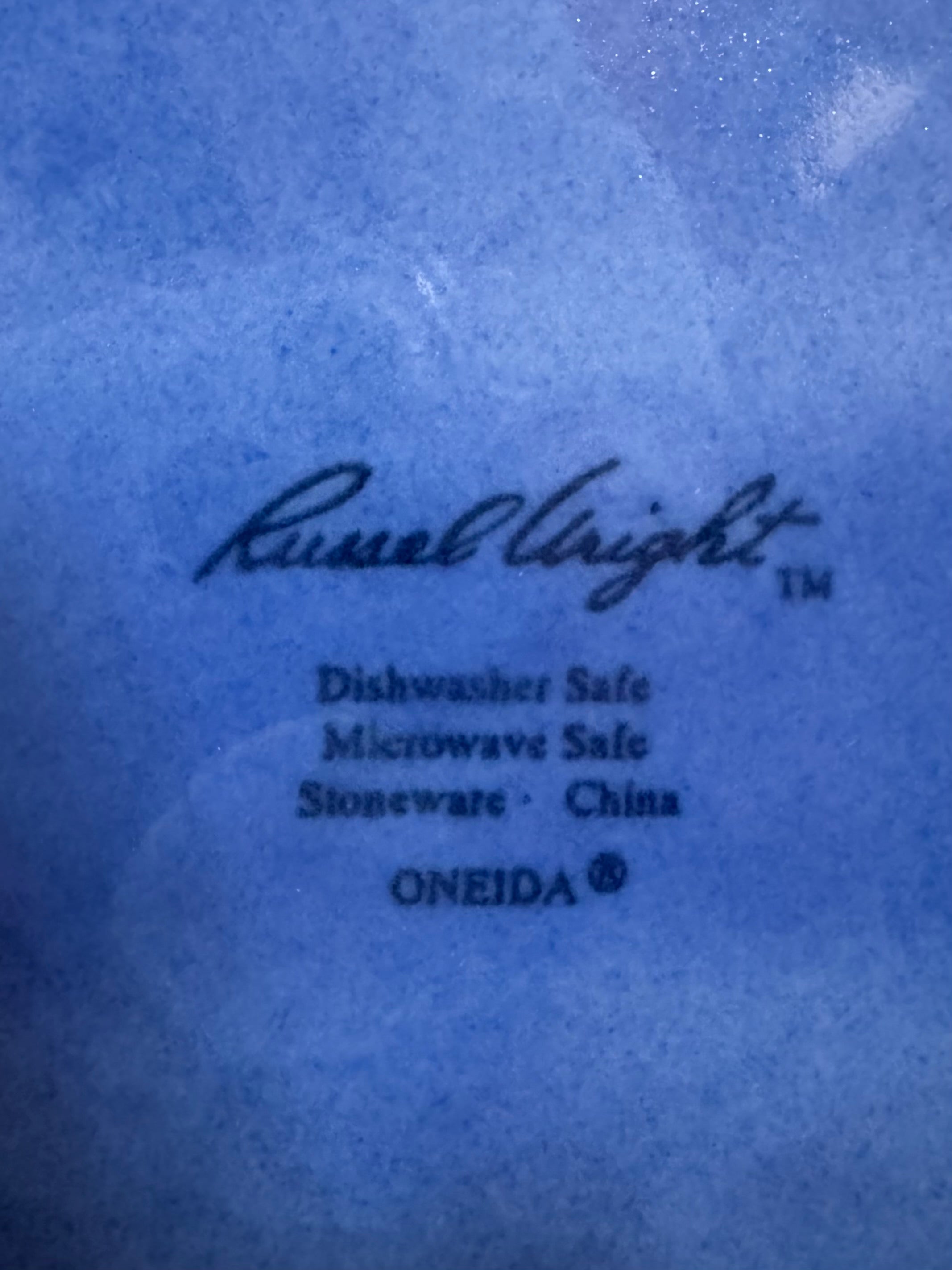 A Russel Wright American Modern stoneware water pitcher in a glossy Manitoga blue glaze is centered against a white background. The pitcher has a teardrop shape, a large handle, and a wide spout