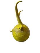 Yellow ceramic sculpture titled 'The Ram Oracle' by Enza Fasano, featuring a round body with intricate, hand-incised patterns and long, stylized ram-like horns