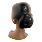 a vintage ceramic bust featuring a woman with brown skin, dark eyes, and orange lips. Her black hair is sleek and parted on the side, pulled back into a low style. She wears a small, round white earring in her right ear lobe. The bust includes her head, neck, and the upper part of her shoulders